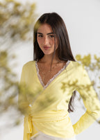 Woman wearing a yellow top with lace details