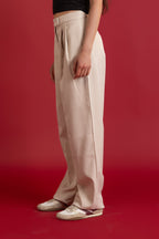 Person wearing beige pants on a red background