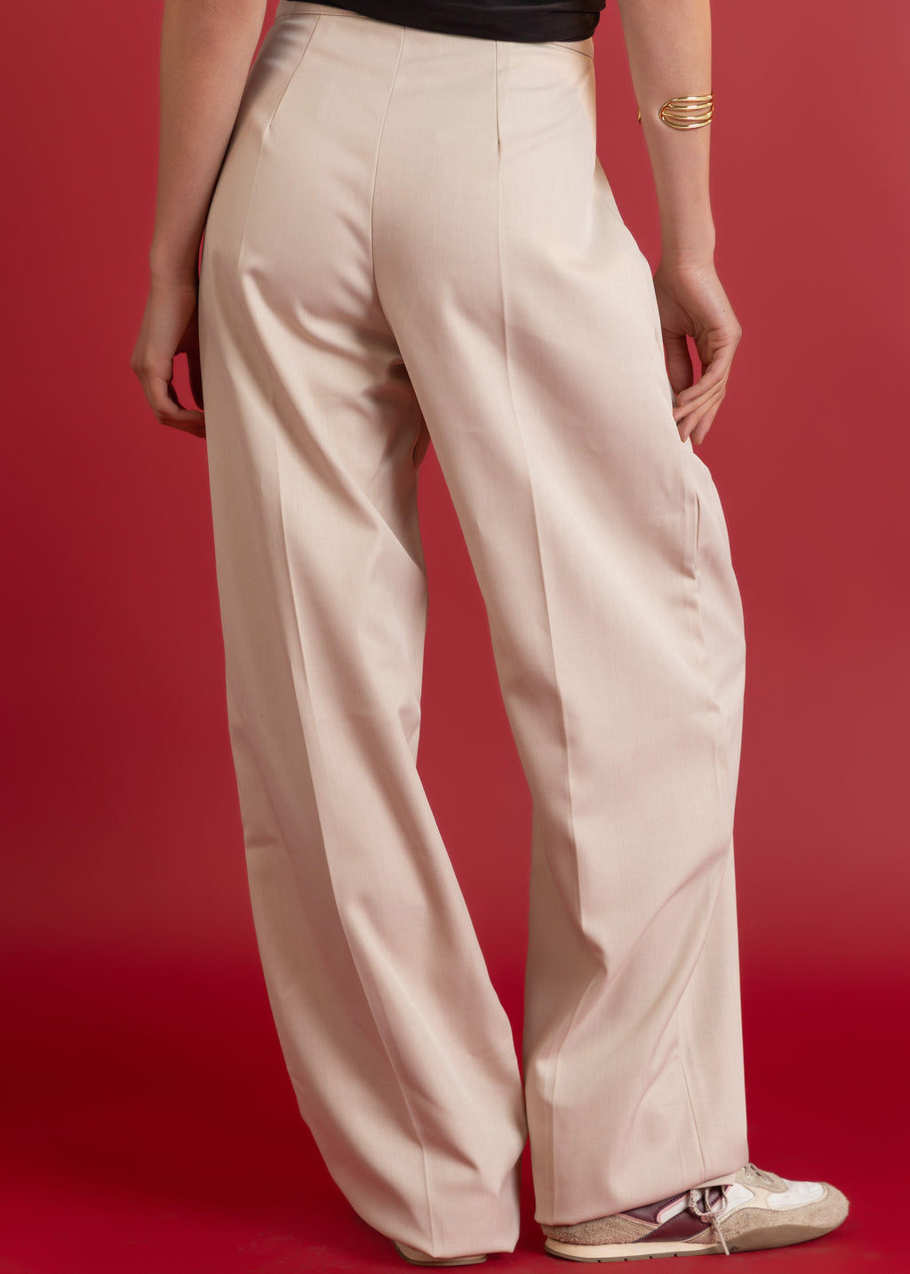 Beige pants worn by a person on a red background