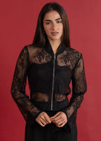 Woman wearing a black lace jacket against a red background