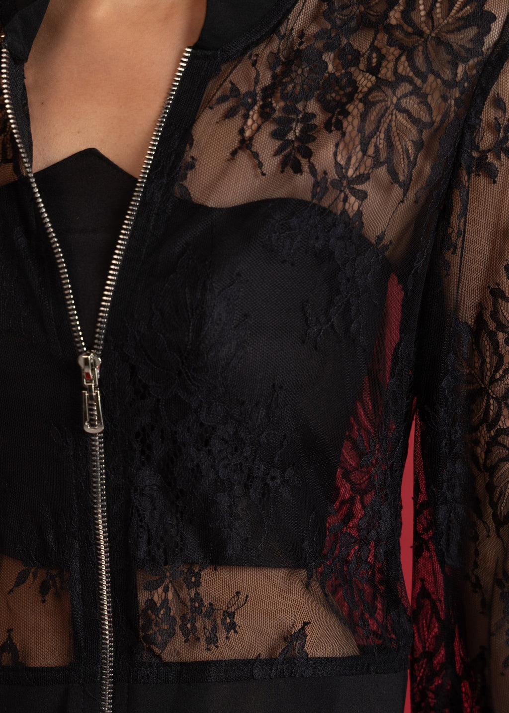 Black lace sheer jacket with zipper on a red background