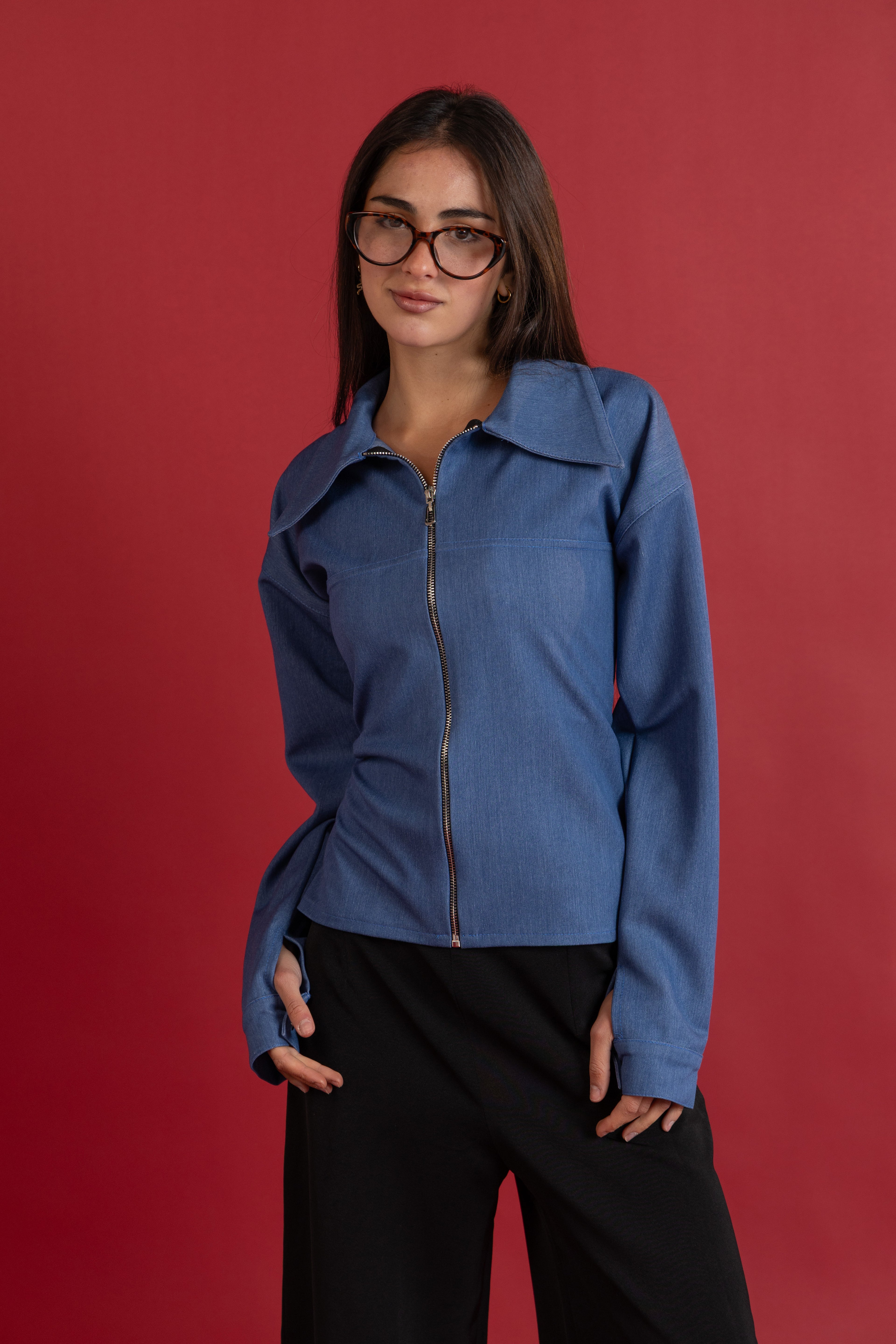 Woman wearing a blue jacket against a red background