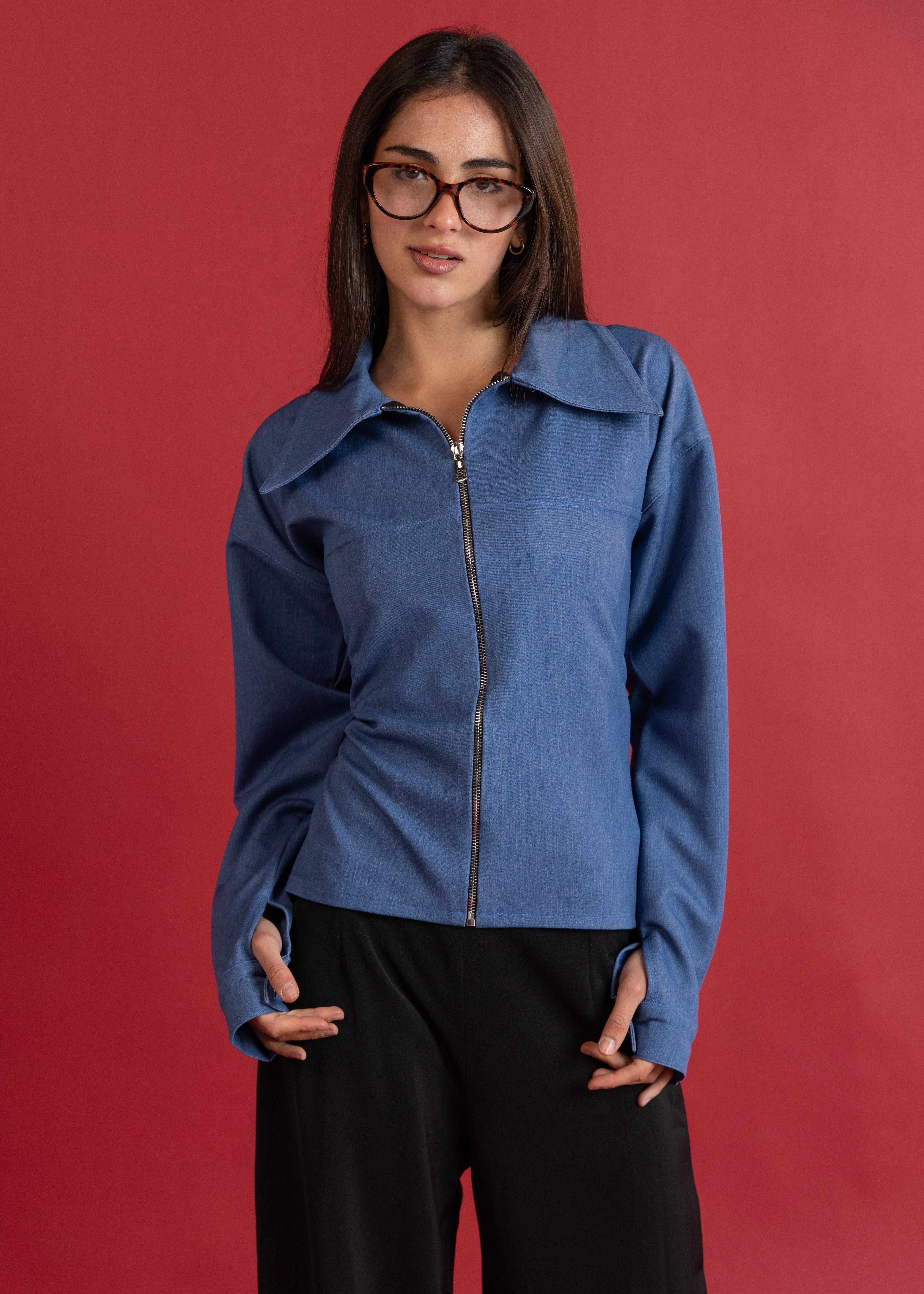 Woman wearing a blue jacket against a red background