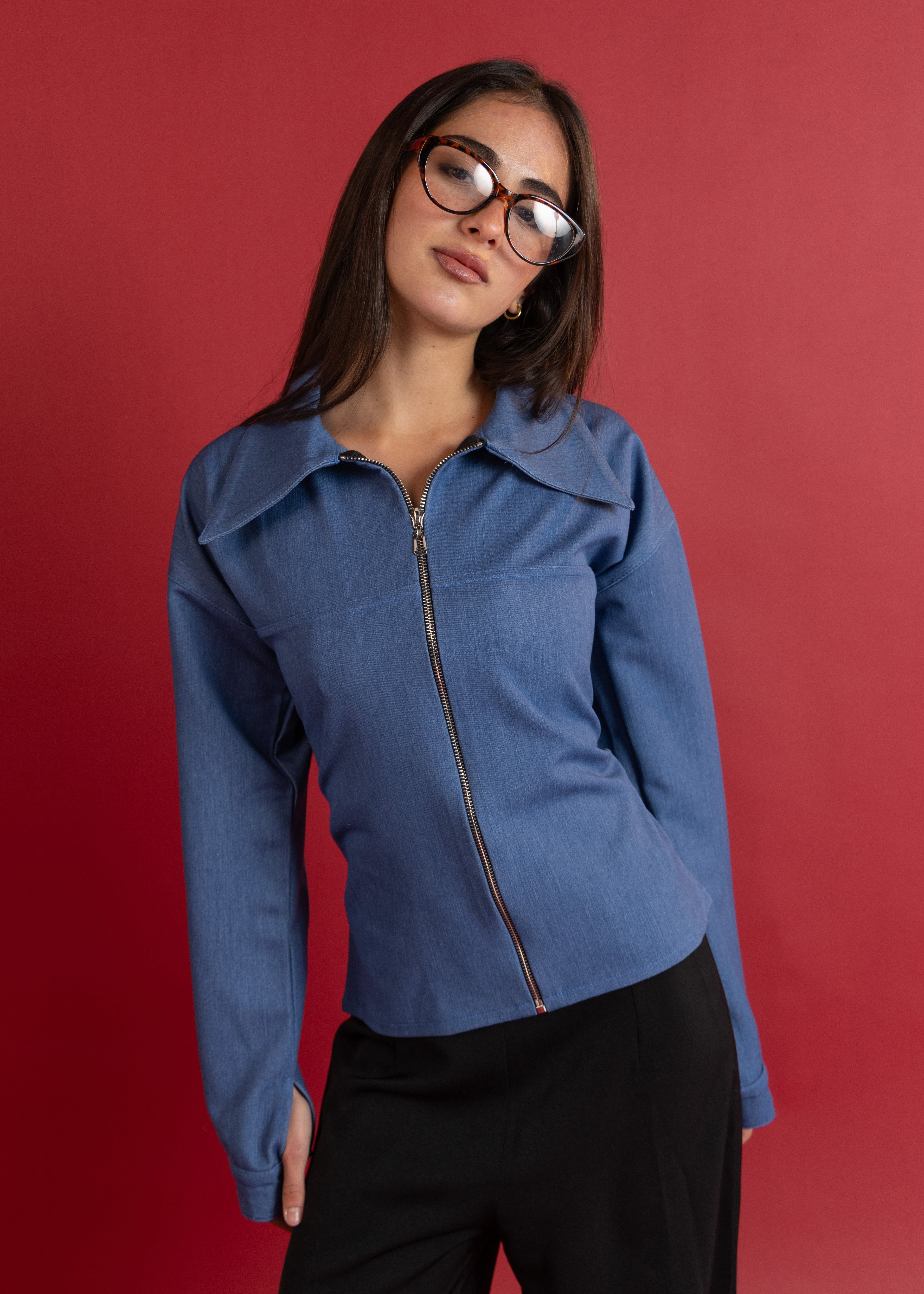Woman wearing a blue jacket against a red background